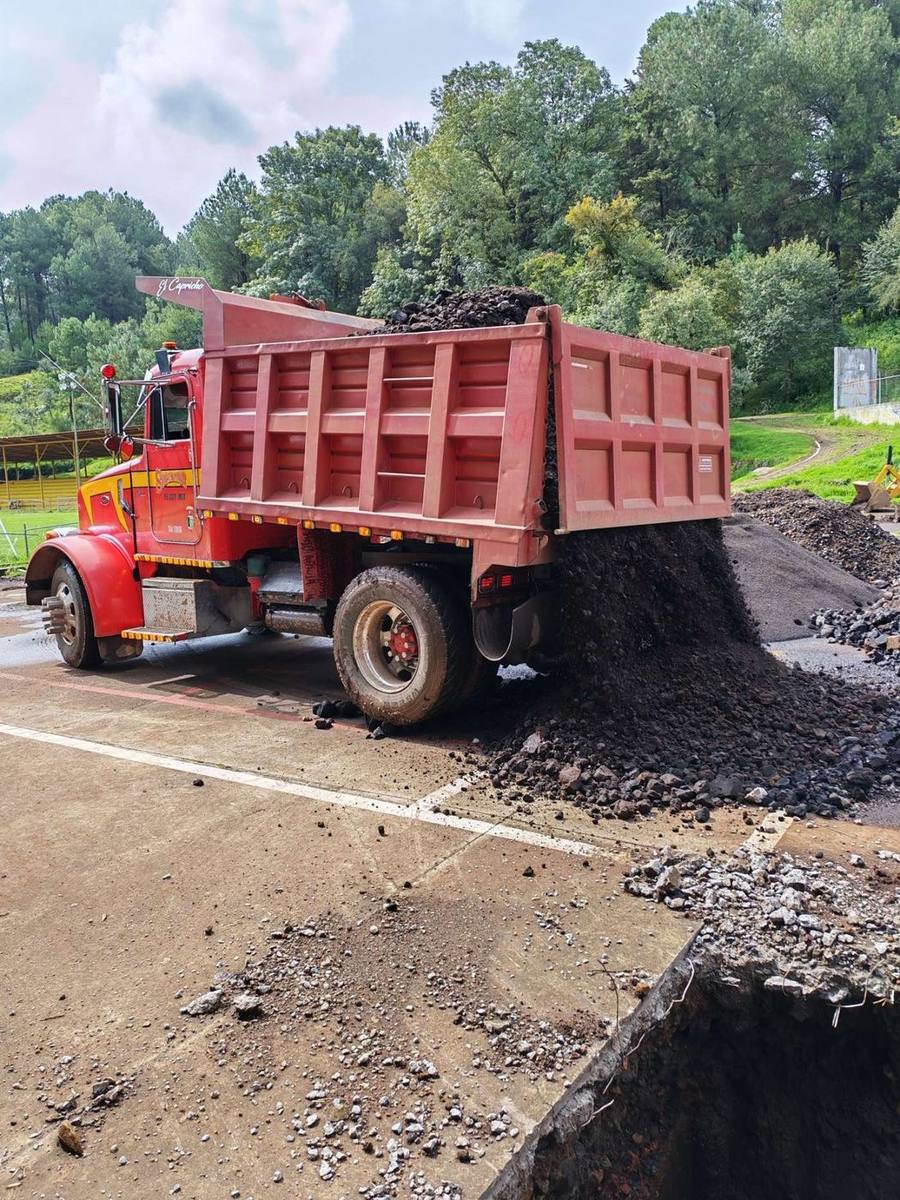 Camión de volteo descargando material en obra