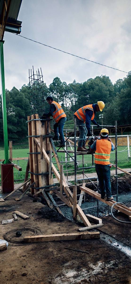 Cuadrilla colando una columna de concreto en obra