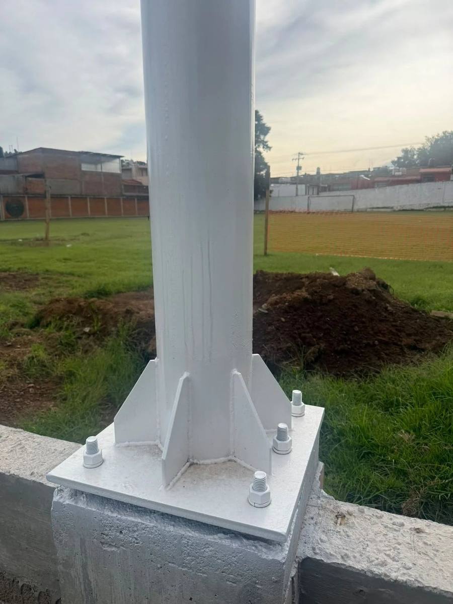 Columna de acero blanca sobre su placa base anclada al concreto