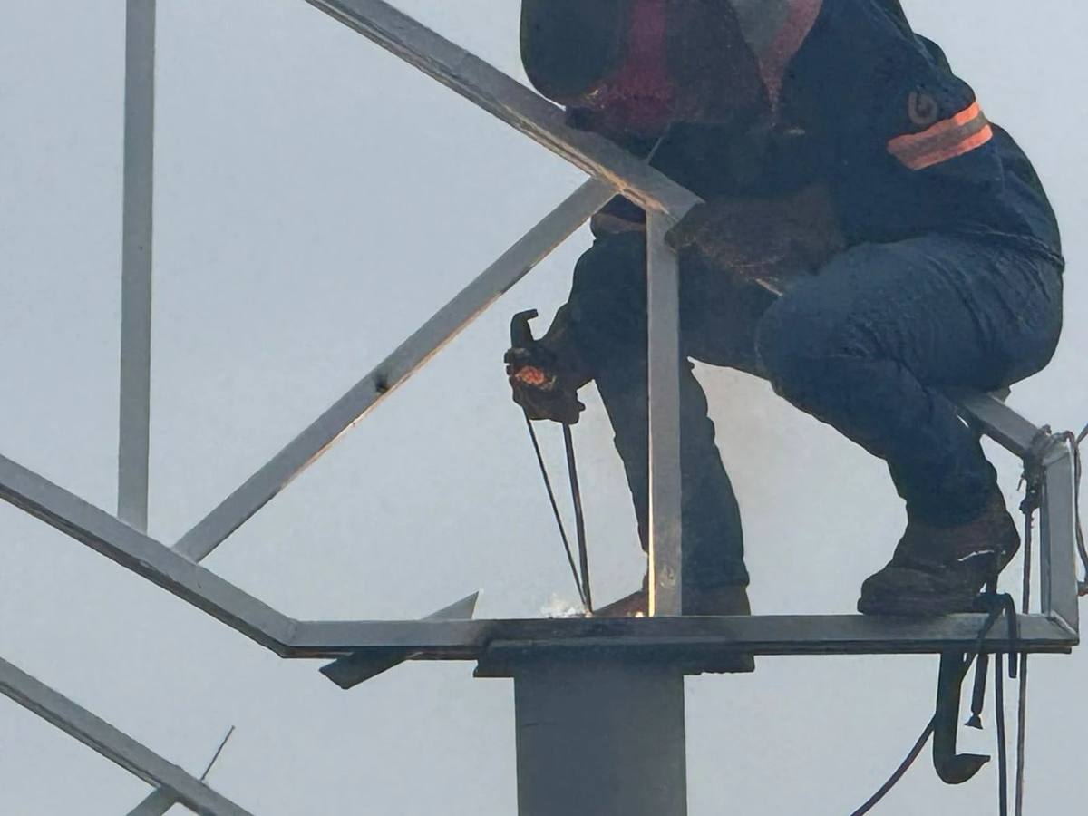 Soldador trabajando en la estructura de acero de una techumbre