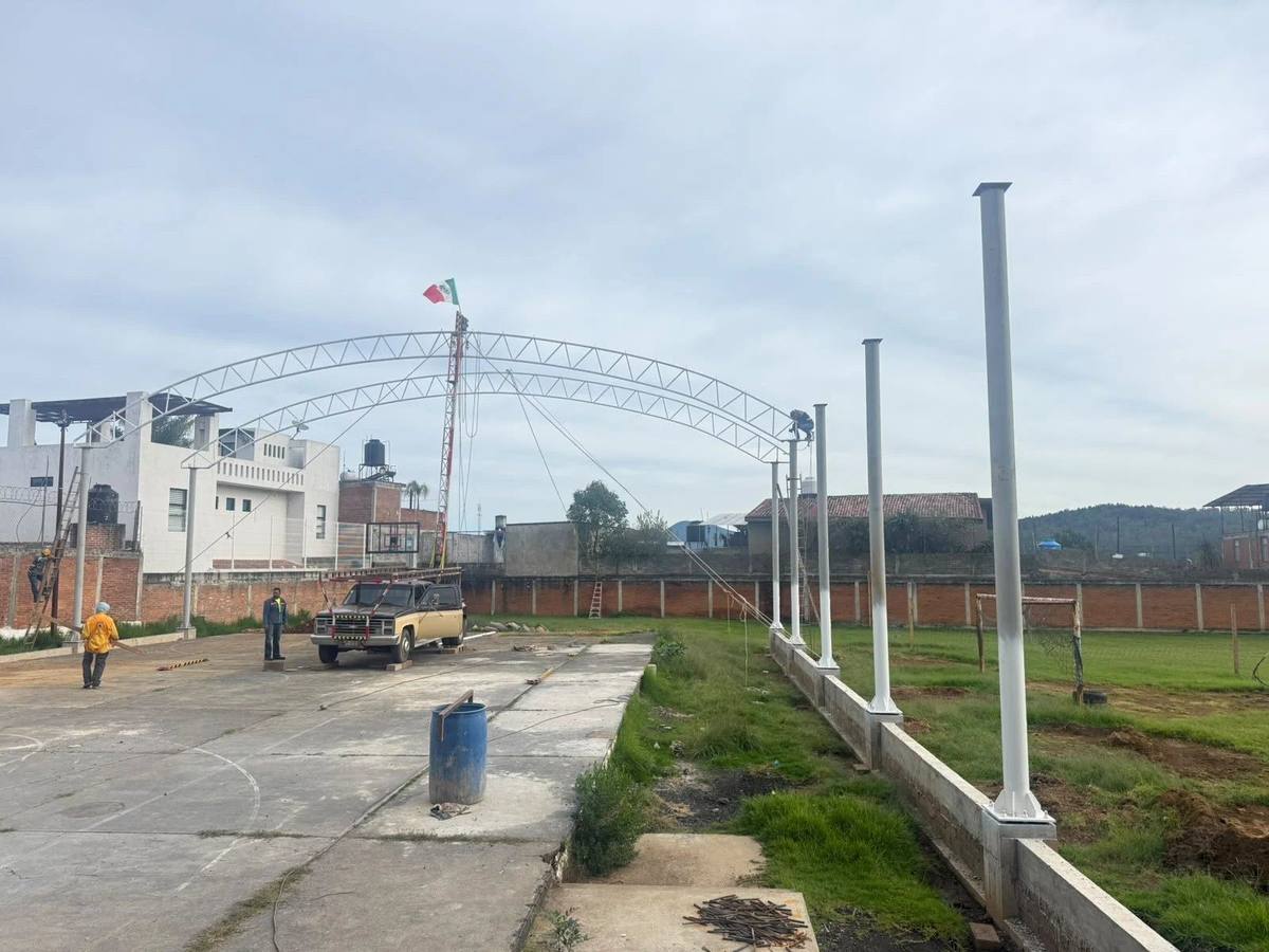 Arcos de acero de un techado sobre una cancha escolar