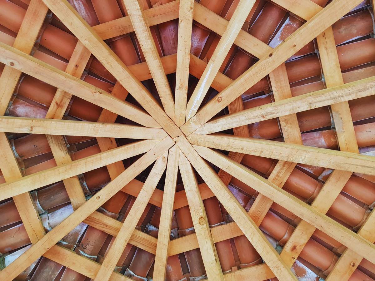 Techumbre de madera en forma radial con teja de barro